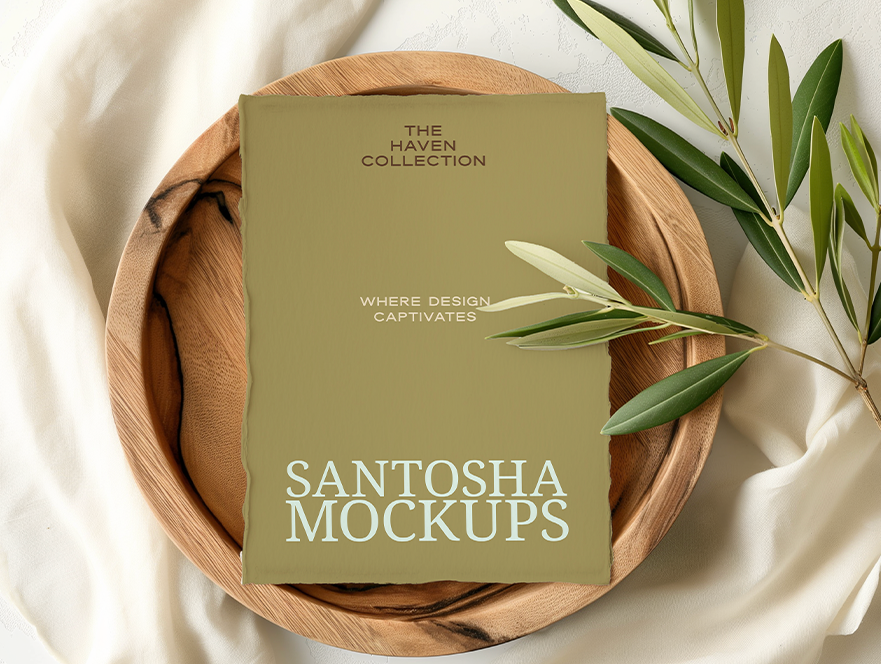 Studio Santosha HAVEN Collection A4 card mockup placed in a wooden bowl, styled with olive branch and draped neutral fabric in soft natural light.