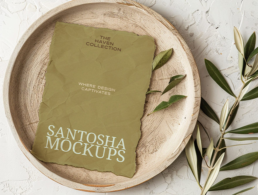 Studio Santosha HAVEN Collection A4 paper mockup with crumpled texture, styled on a wooden plate with olive branches and natural stone background in warm light.