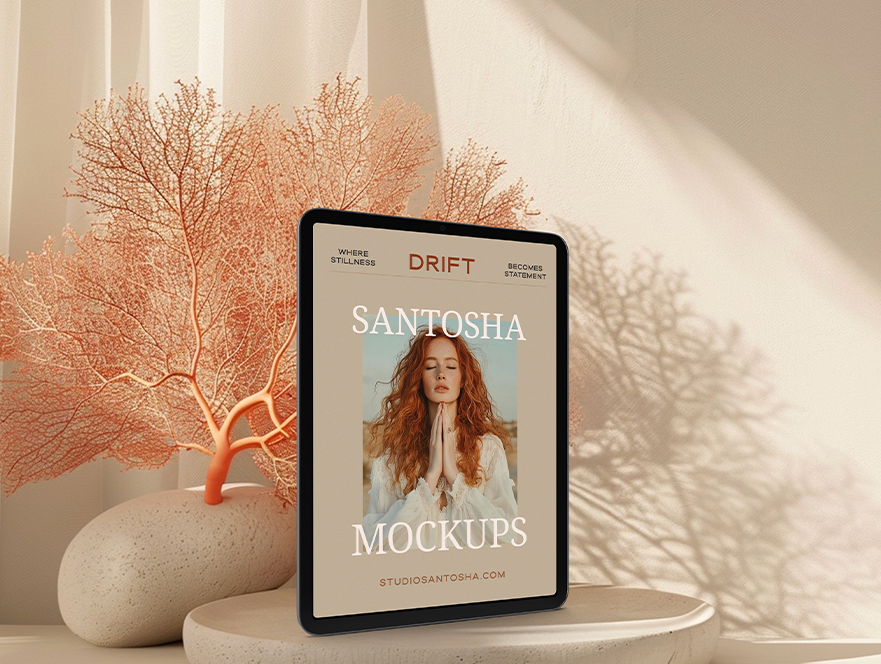 iPad mockup from the DRIFT Collection by Studio Santosha, displayed on a pedestal with coral decoration and soft fabric backdrop in natural light.
