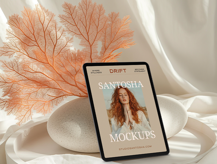iPad mockup from the DRIFT Collection by Studio Santosha, showing a woman’s portrait cover design with coral and stone accents on a soft fabric background.

