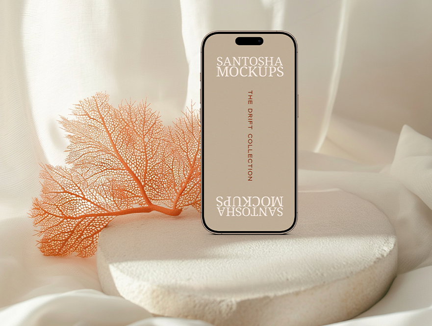 iPhone mockup from the DRIFT Collection by Studio Santosha, styled on a soft textured surface with coral decoration and fabric backdrop.