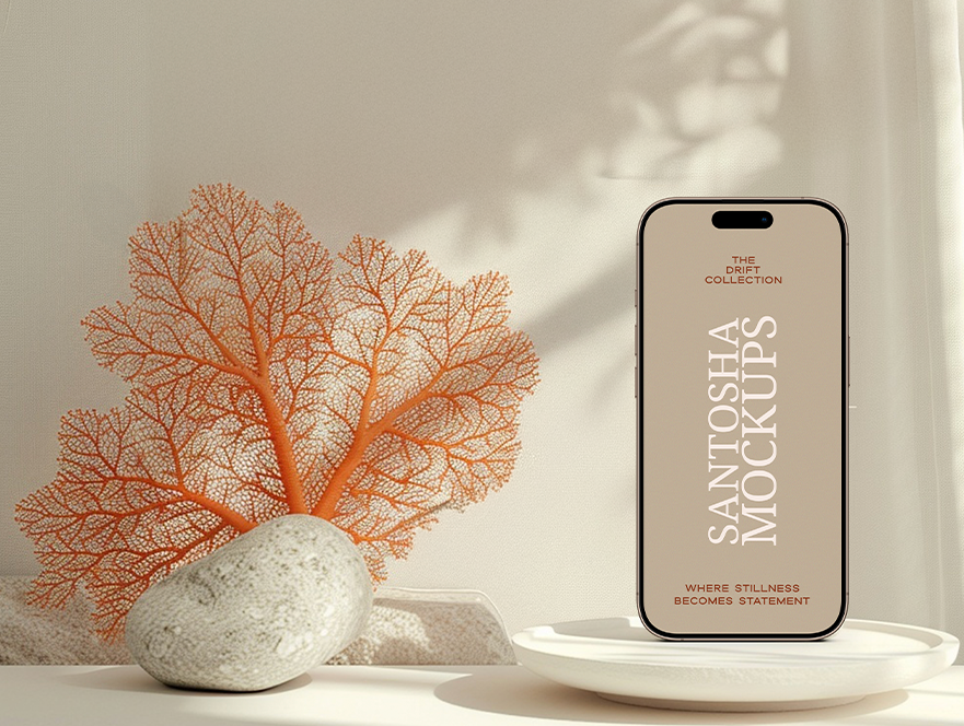 iPhone mockup from the DRIFT Collection by Studio Santosha, displayed on a white dish with coral decoration, natural stone, and soft fabric backdrop.