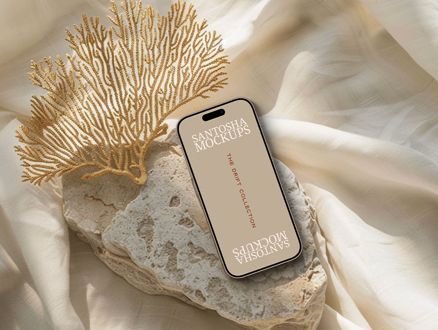 iPhone mockup from the DRIFT Collection by Studio Santosha, styled on a textured stone surface with golden coral decoration and soft fabric backdrop.