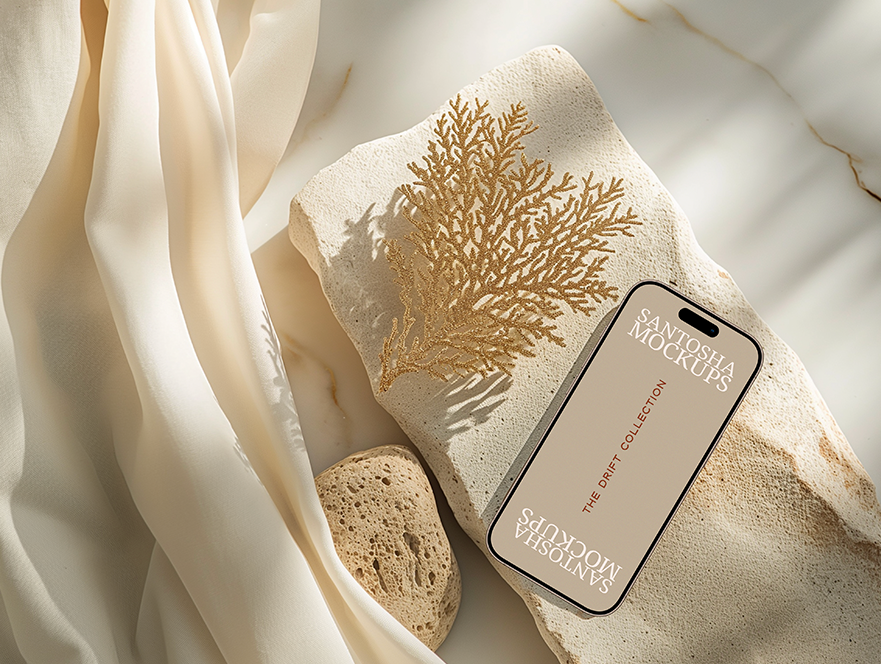 iPhone mockup from the DRIFT Collection by Studio Santosha, styled on a textured stone surface with golden coral decoration and soft fabric backdrop.
