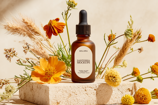 Amber glass beauty bottle mockup with dropper cap, styled on textured stone with warm golden floral elements and soft neutral lighting, part of the Studio Santosha Solara Solo Edit collection.