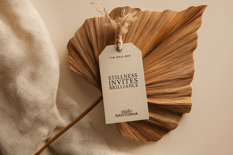 Hanging tag mockup on dried sculptural leaf from the Sattva Solo Edit Collection by Studio Santosha with warm neutral background and soft fabric texture