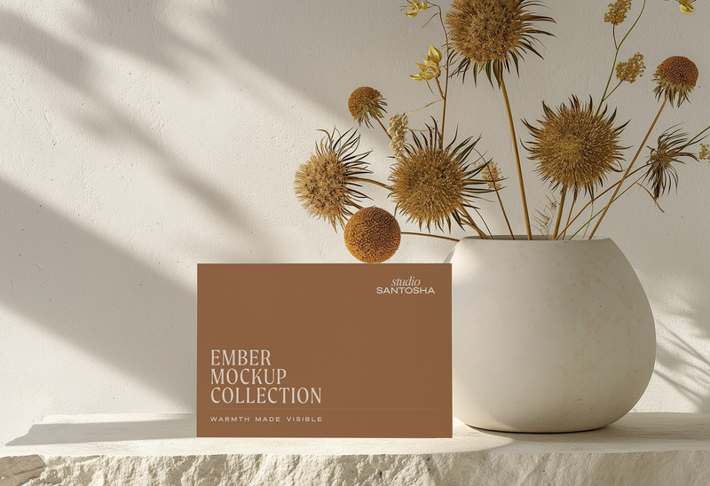 Studio Santosha Ember dual header website mockup with cropped collection card, large ceramic vase and dried floral styling in warm neutral sunlight
