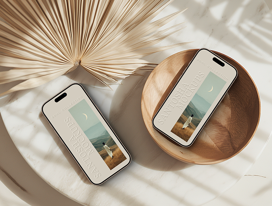 Dual iPhone mockup from the SOHL Collection by Studio Santosha — two smartphones with scenic wallpapers displayed on a round surface with a wooden bowl and dried palm leaf, styled in warm neutral tones.