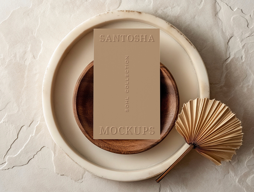 Vertical business card mockup from the SOHL Collection, styled on layered ceramic plates with a decorative palm fan, in soft neutral tones