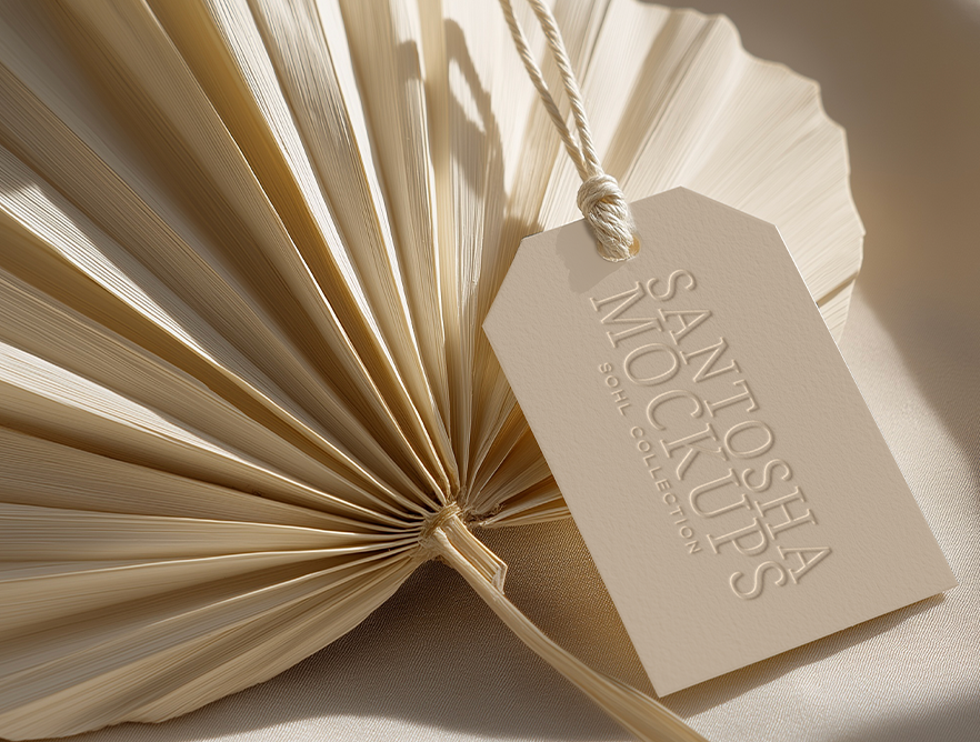 Minimal beige hangtag mockup from the SOHL Collection from Studio Santosha, displayed on a dried palm leaf with soft neutral shadows